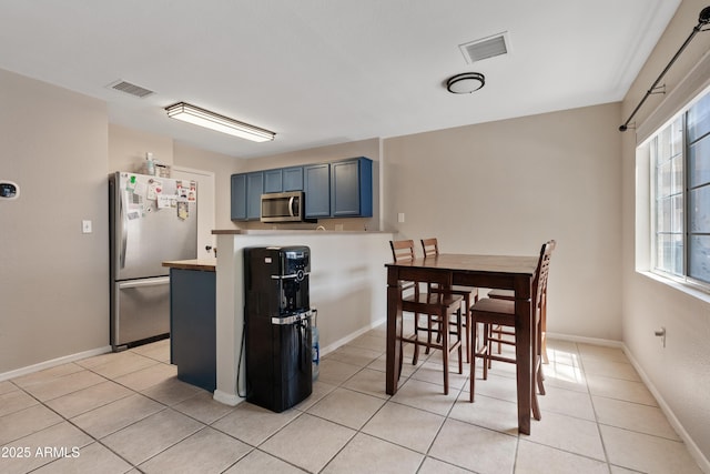 125 S 56th St Unit 27, Mesa, AZ 85206 - kitchen featuring stainless steel appliances, blue cabinetry, and light tile patterned floors
