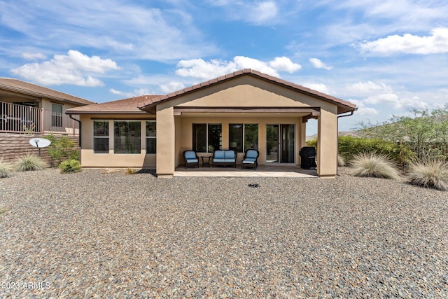 back of house featuring a patio and outdoor lounge area