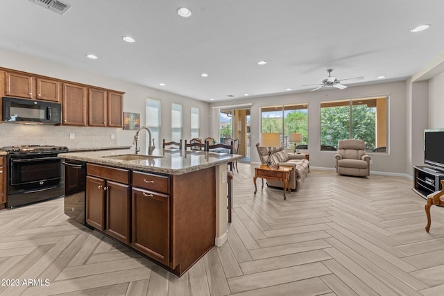 kitchen with light parquet floors, ceiling fan, black appliances, backsplash, and sink