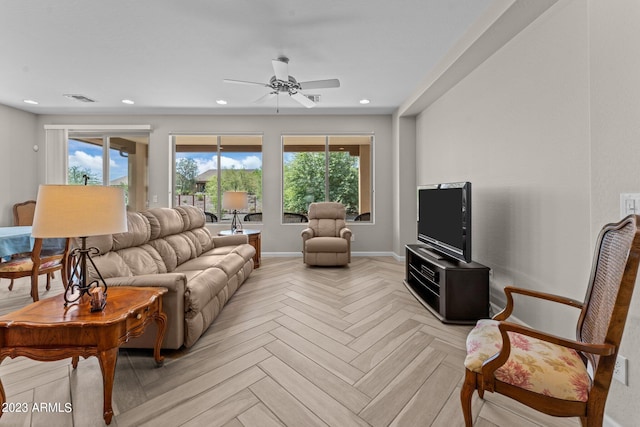 living room with plenty of natural light, light parquet flooring, and ceiling fan