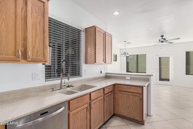 kitchen with light tile patterned floors, stainless steel dishwasher, sink, kitchen peninsula, and pendant lighting