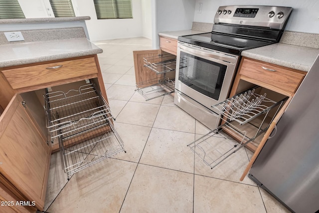 kitchen featuring light tile patterned floors and stainless steel electric range