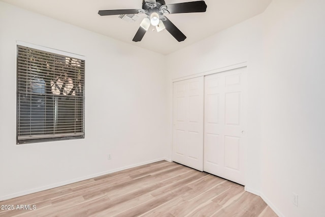 unfurnished bedroom featuring ceiling fan, a closet, and light hardwood / wood-style flooring