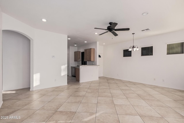 unfurnished living room with ceiling fan with notable chandelier and light tile patterned floors