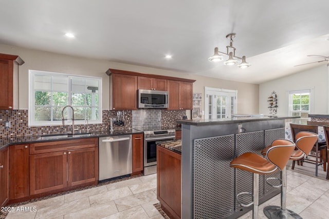 2508 N Karen Dr, Chandler, AZ 85224 - kitchen featuring appliances with stainless steel finishes, a sink, tasteful backsplash, a kitchen bar, and recessed lighting