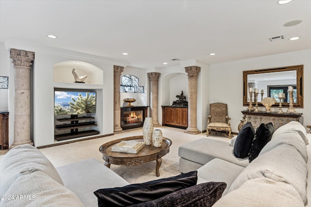 living room with light carpet, crown molding, and ornate columns