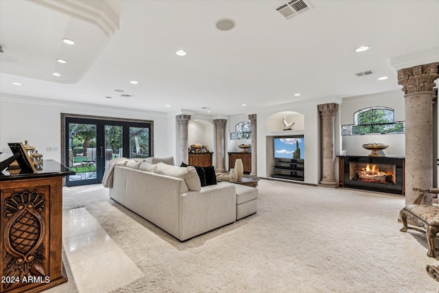 living room featuring plenty of natural light, ornamental molding, and ornate columns