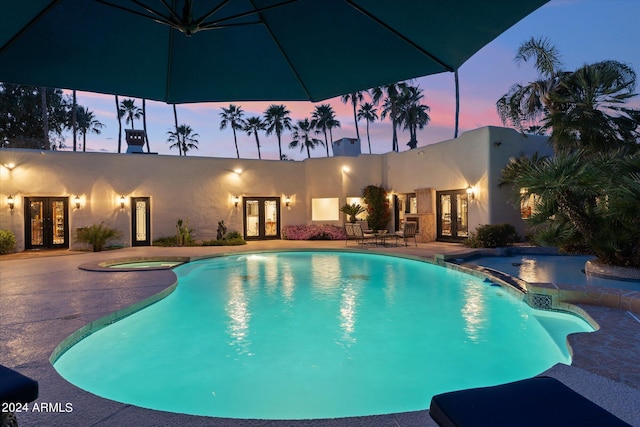 pool at dusk with a patio area