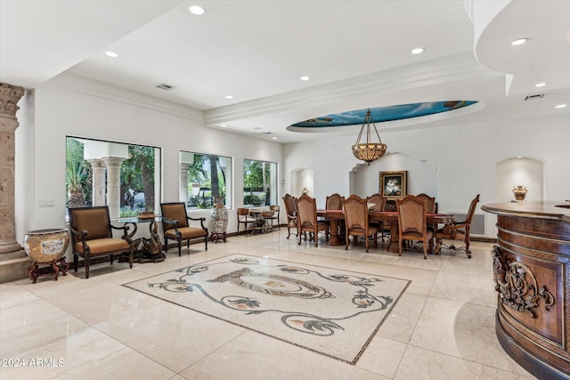 living room featuring crown molding, a raised ceiling, light tile flooring, and ornate columns