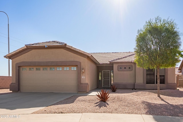 single story home featuring a garage, concrete driveway, a tiled roof, and stucco siding