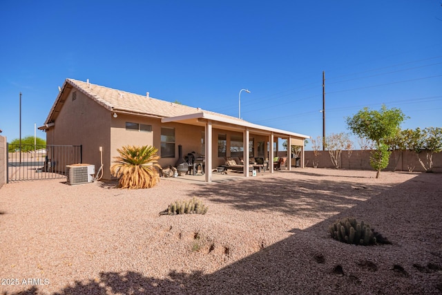 back of property with a patio area, a fenced backyard, central AC unit, and stucco siding