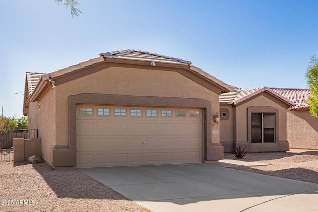 ranch-style house featuring a tile roof, driveway, fence, a garage, and stucco siding