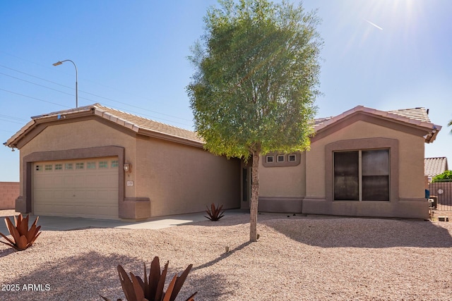 ranch-style home featuring driveway, a tiled roof, fence, a garage, and stucco siding