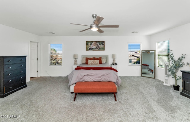 bedroom with ceiling fan, multiple windows, and light colored carpet