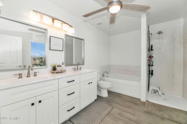 bathroom featuring visible vents, a sink, a garden tub, and wood finished floors