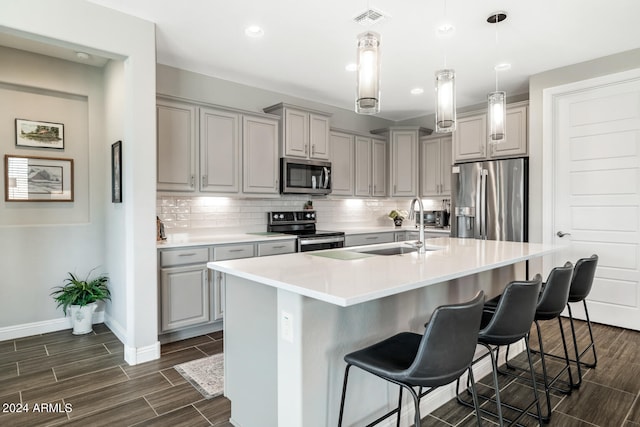 kitchen featuring an island with sink, a breakfast bar area, and stainless steel appliances