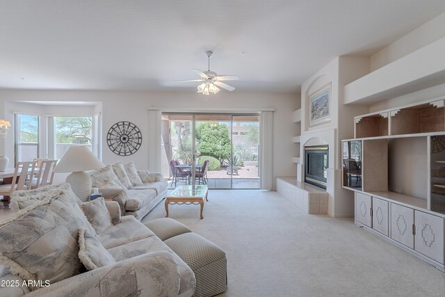 14806 E Lookout Ledge, Fountain Hills, AZ 85268 - living room featuring light colored carpet, ceiling fan, a tiled fireplace, and built in shelves