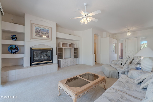 14806 E Lookout Ledge, Fountain Hills, AZ 85268 - carpeted living area featuring a tile fireplace, arched walkways, a ceiling fan, and built in features