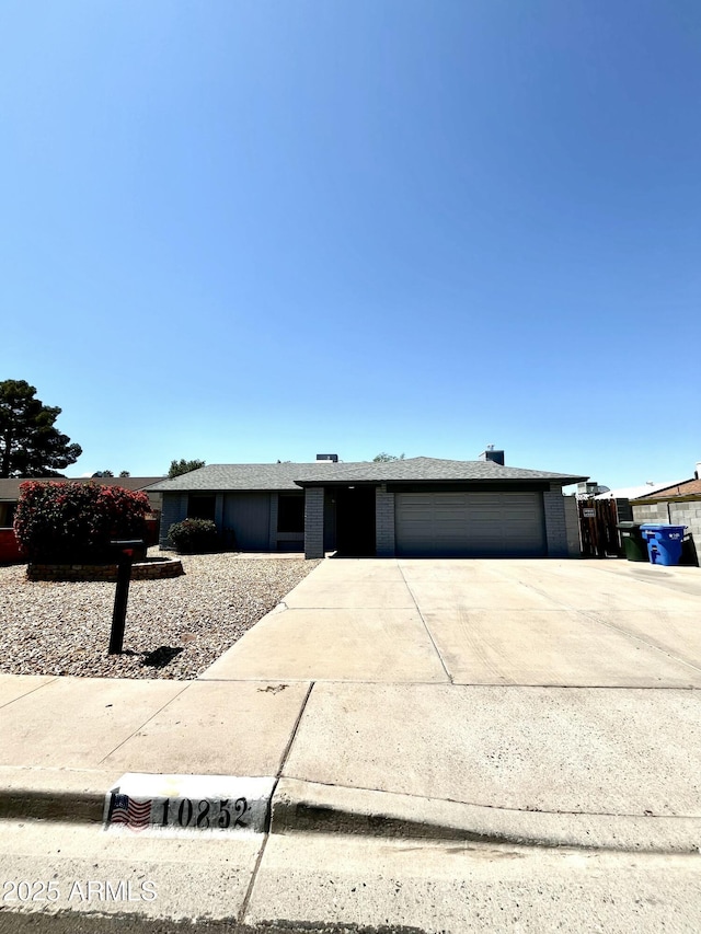 view of front of house with brick siding, driveway, and a garage