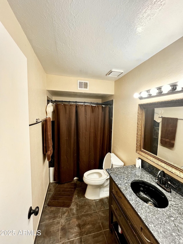 full bath with visible vents, toilet, vanity, and a textured ceiling
