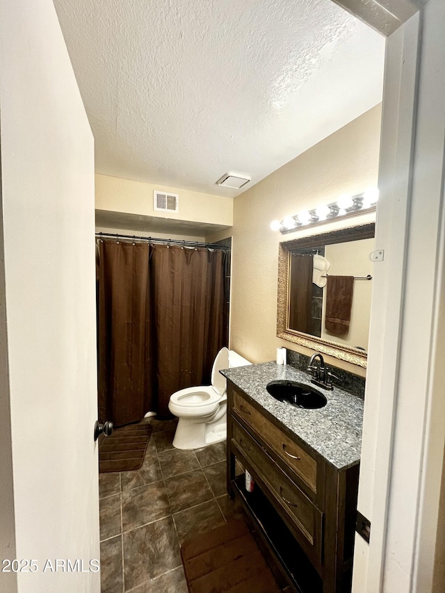 bathroom with vanity, visible vents, a textured ceiling, and toilet
