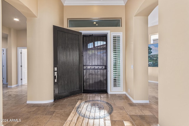 entrance foyer with crown molding and a wealth of natural light