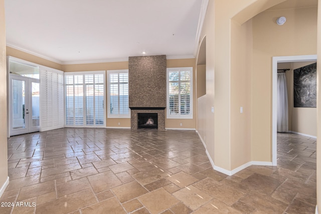 unfurnished living room featuring a fireplace, french doors, and crown molding