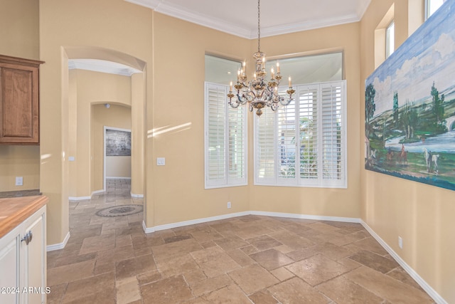 unfurnished dining area featuring a chandelier and ornamental molding