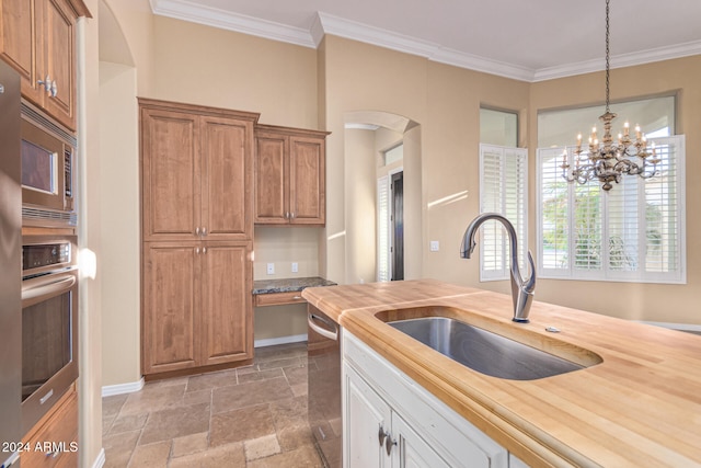 kitchen featuring butcher block countertops, pendant lighting, stainless steel appliances, and an inviting chandelier