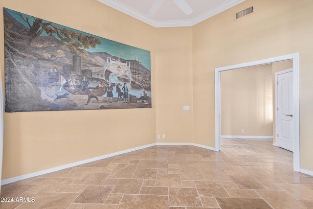 empty room featuring ceiling fan, a towering ceiling, and ornamental molding