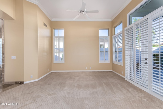 carpeted empty room featuring ornamental molding, ceiling fan, and a healthy amount of sunlight