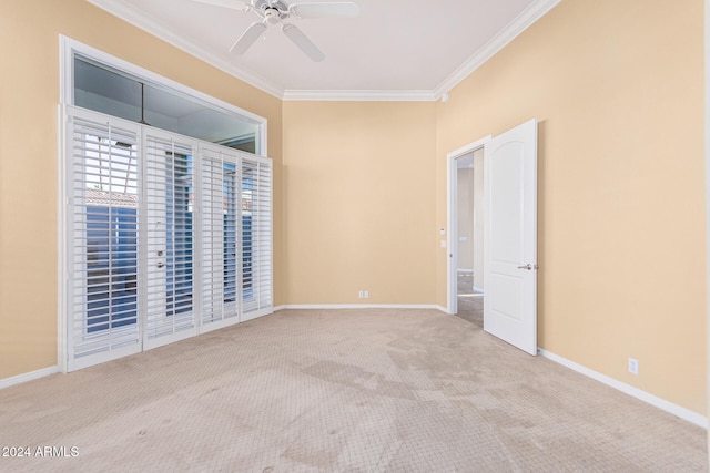 empty room featuring light carpet, ceiling fan, and ornamental molding