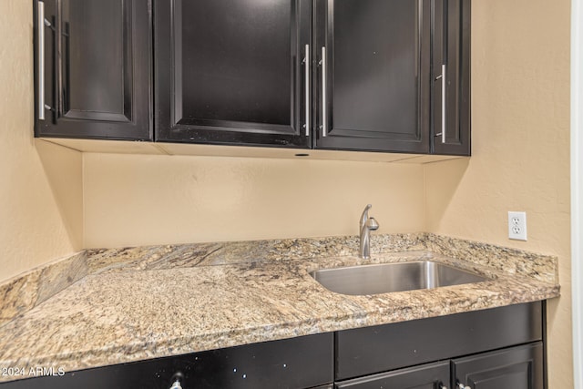 kitchen featuring light stone countertops and sink