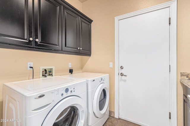 laundry room featuring cabinets, light tile patterned floors, and washer and clothes dryer