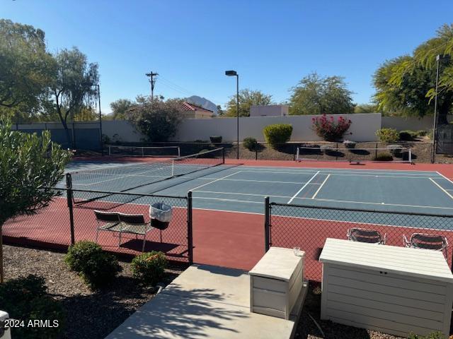 view of tennis court with basketball hoop