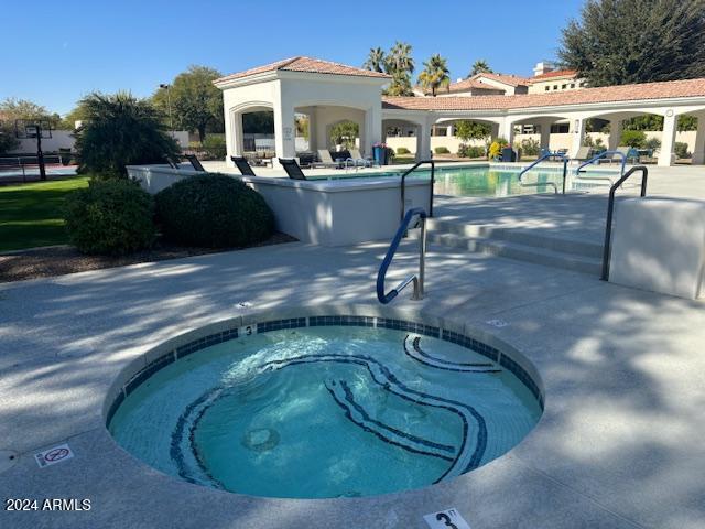 view of swimming pool featuring a patio area and a hot tub