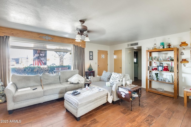 living room featuring hardwood / wood-style flooring, a textured ceiling, and ceiling fan