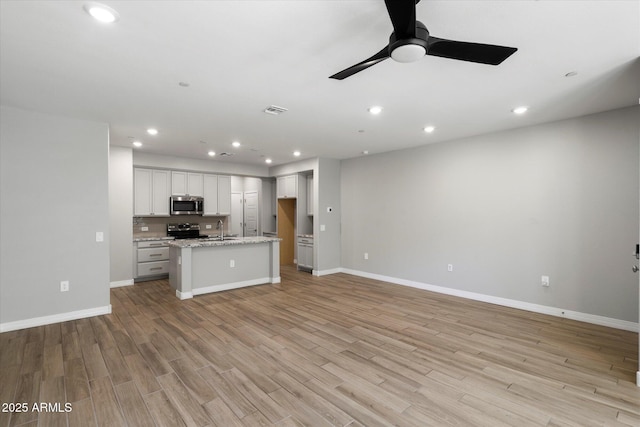 1823 E Chelsea Ln Unit 106, Gilbert, AZ 85295 - unfurnished living room featuring a ceiling fan, baseboards, light wood finished floors, and recessed lighting