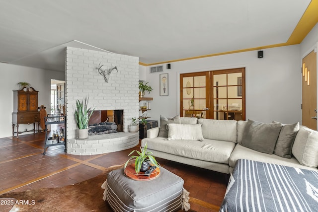 living area featuring french doors, a fireplace, and visible vents