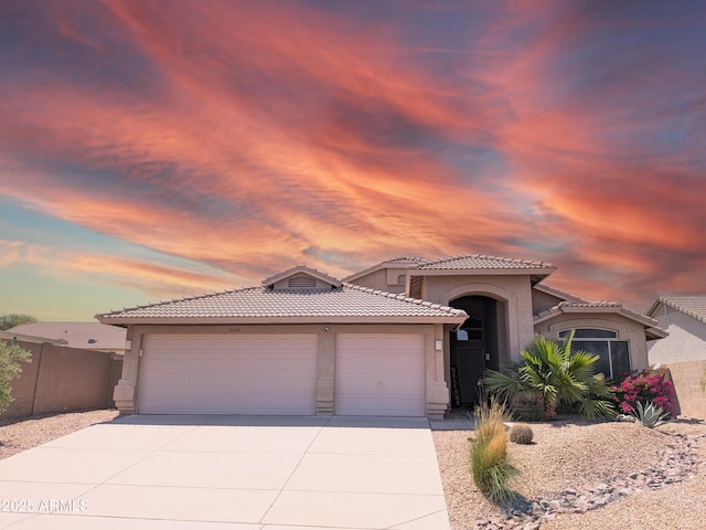 11424 S Obispo Dr, Goodyear, AZ 85338 - mediterranean / spanish-style house featuring a garage, concrete driveway, stucco siding, and a tiled roof