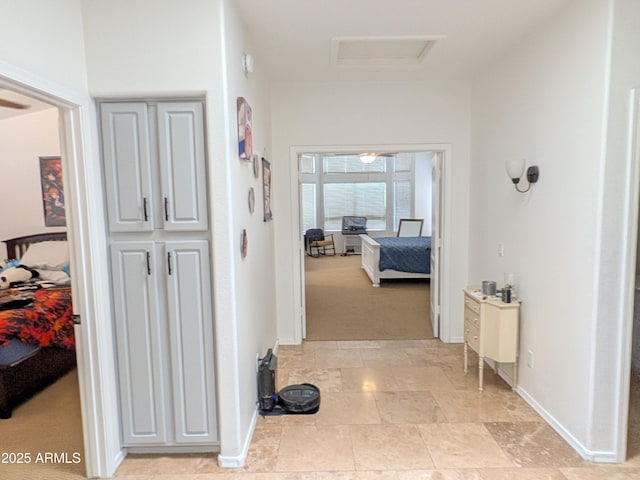 11424 S Obispo Dr, Goodyear, AZ 85338 - corridor with attic access, baseboards, and light stone finish floors