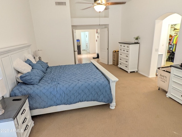 11424 S Obispo Dr, Goodyear, AZ 85338 - bedroom with light carpet, arched walkways, a spacious closet, and ceiling fan