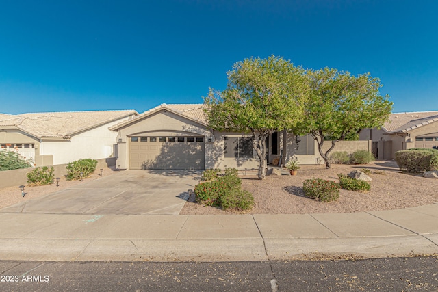 view of front of house featuring a garage, concrete driveway, a tiled roof, and stucco siding