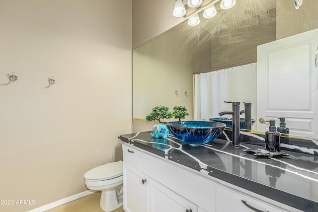 full bathroom with toilet, tile patterned floors, baseboards, and vanity