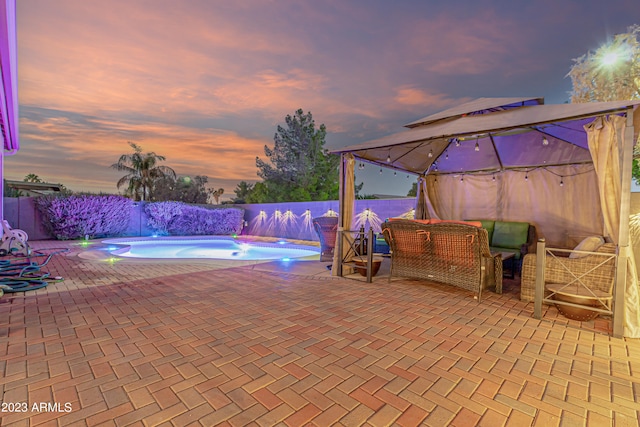 pool at dusk with a fenced in pool, a fenced backyard, and a patio