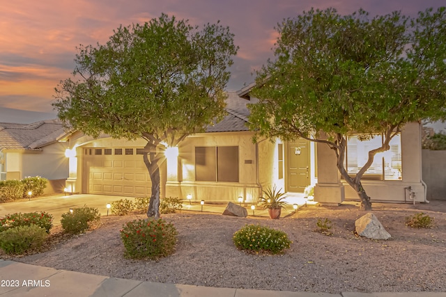 view of front facade with concrete driveway, an attached garage, and stucco siding