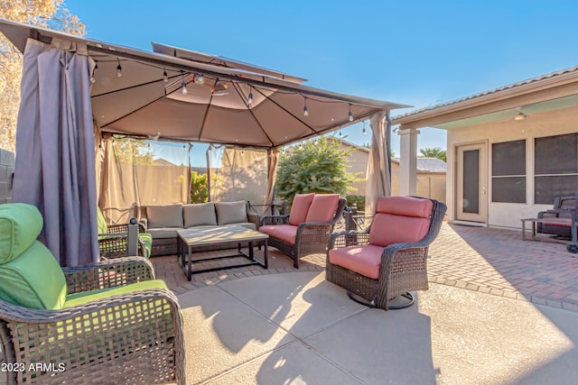 view of patio with fence, an outdoor living space, and a gazebo