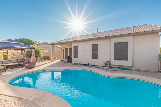 outdoor pool with an outdoor hangout area and a patio