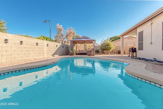 view of swimming pool with a fenced in pool, a fenced backyard, and a gazebo