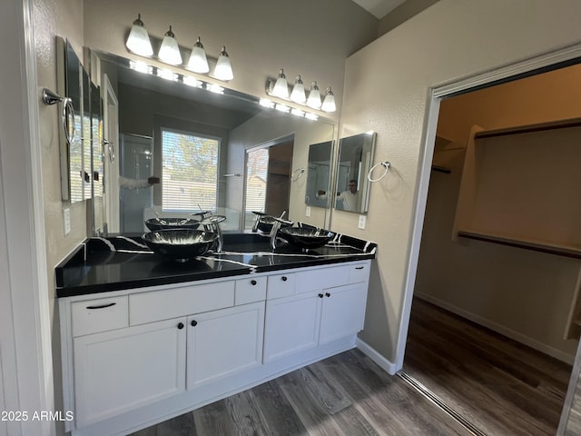 full bath featuring vanity, baseboards, and wood finished floors